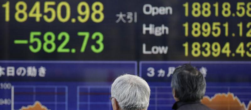 Peatones observan una pantalla en la que se muestra información bursátil en Tokio (Japón) el 4 de enero de 2016. La Bolsa de Tokio se desplomó. Foto: EFE