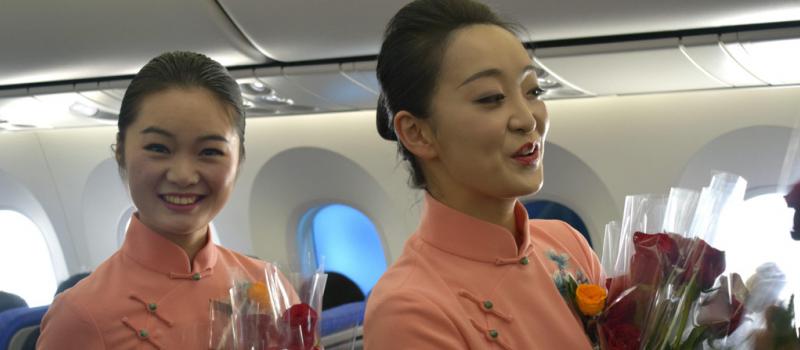 Dos azafatas de China Southern entregan las rosas ecuatorianas que el consulado de Ecuador en Cantón (China) ha regalado hoy a todas las pasajeras de cincuenta vuelos de la aerolínea China Southern. Foto: EFE