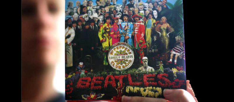 Una mujer sostiene la portada del disco  ‘Sgt. Peppers Lonely Hearts Club Band’. Foto: AFP