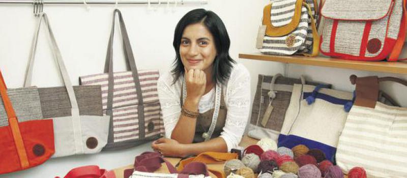 Verónica Buitrón enseña los bolsos que diseña y confecciona con telas de tejedores de Cotopaxi. Foto: Diego Pallero / LÍDERES