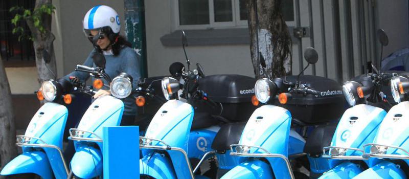 Una mujer usa una moto eléctrica de la empresa Econduce. Foto: Mario Guzmán/ EFE.