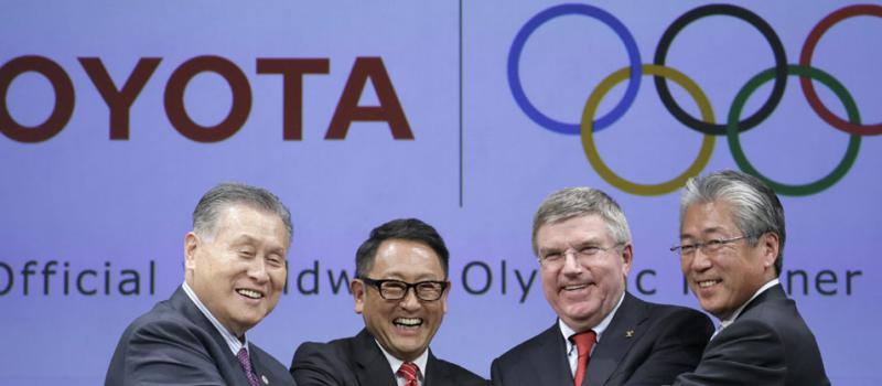 El presidente del Comité Olímpico Internacional (COI), Thomas Bach (2-d), estrecha la mano con el presidente del comité organizador de Tokio 2020, Yoshiro Mori (i); el presidente de Toyota Motor, Akio Toyoda (2-i); y el presidente de la Comisión de Merca