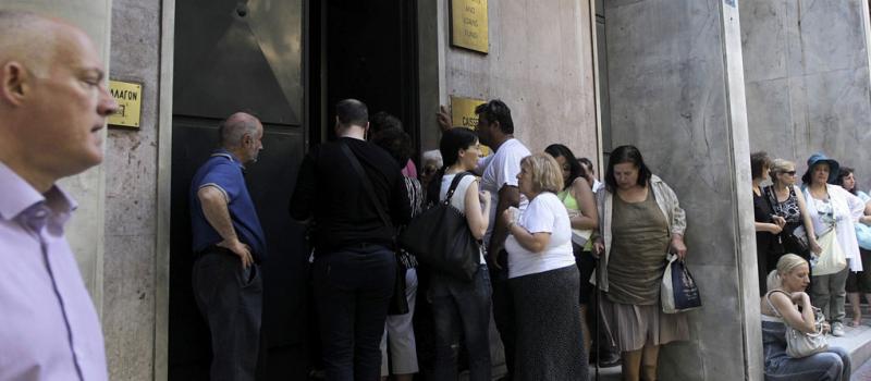 Un grupo de personas hace cola para realizar sus transacciones en el Fondo de Depósitos y Préstamos en Atenas (Grecia) el 24 de julio de 2015. Foto: Orestis Panagiotou/ EFE.
