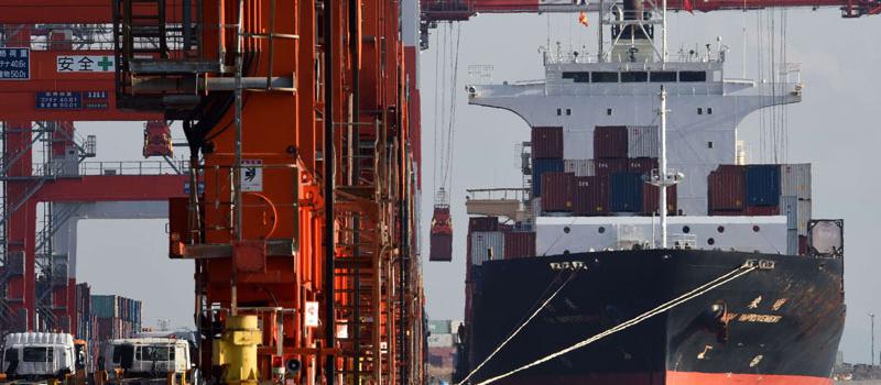 Un contenedor se carga en un buque de carga en un muelle en Tokio el 18 de febrero de 2016. Japón se abrió de nuevo a un déficit comercial en enero ya que las exportaciones a China se desplomaron , mostraron datos oficiales el 18 de febrero , lo que subra