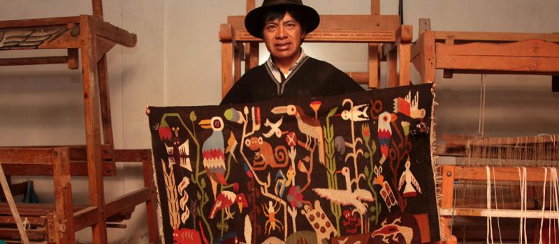 Toribio Masaquiza, en su taller, teje en los telares los tapices que luego envía a Galápagos y a otras ciudades. Foto: Glenda Giacometti / LÍDERES