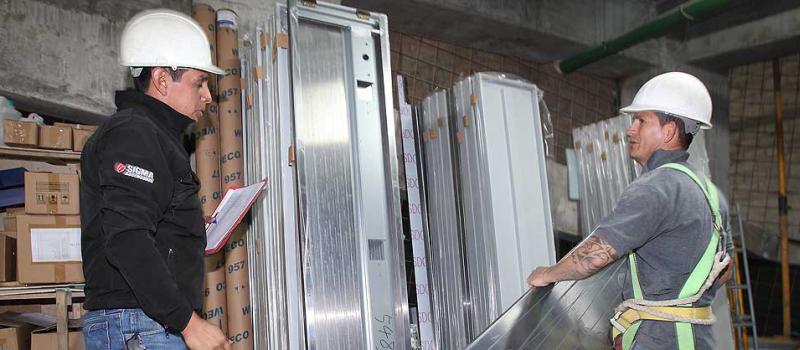Dos empleados de  Ascensores Ecuatorianos preparan las partes de la cabina del elevador para  su instalación en un edificio ubicado en el norte de Quito. Fotos: Vicente Costales / LÍDERES