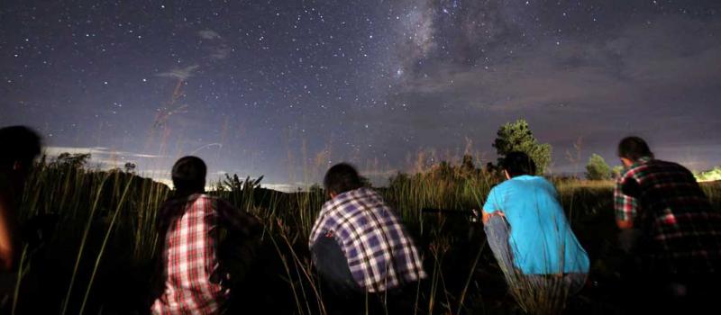 La personas miran la lluvia de meteoros Perseidas en el cielo nocturno cerca de Yangón. Foto: AFP