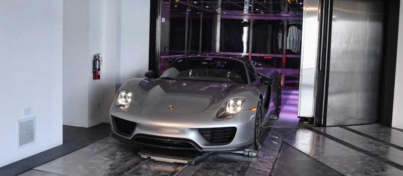 Un Porsche llega al condominio en el asesor automático para autos en la torre de lujo.