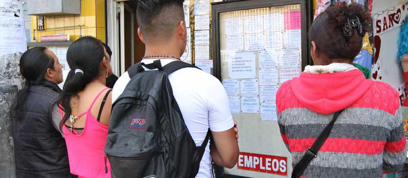 Un grupo de personas ve una pancarta con ofertas de empleos en Tumbaco. Foto: Eduardo Terán / LÍDERES