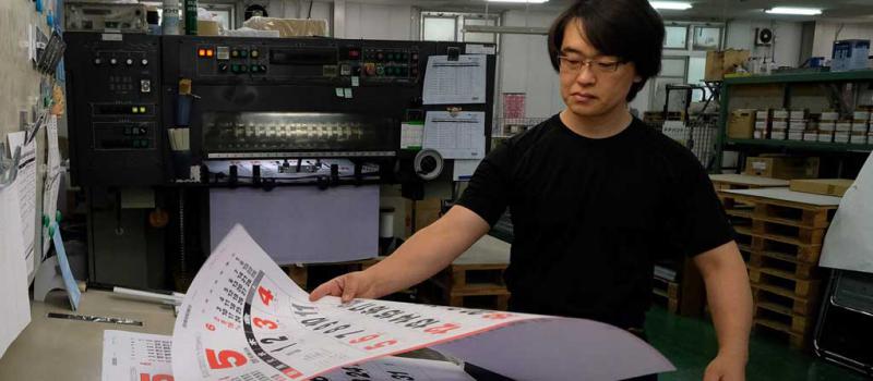 Un empleado de una imprenta revisa un  calendario. El gobierno japonés estableció medidas para que los trabajadores disminuyan sus horas extras.  Foto: Kazuhiro Nogi / AFP