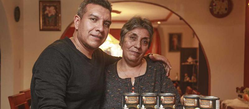 Gladys Ordóñez y su hijo Carlos Tenezaca muestran los envases de 425 gramos de Cerdo Hornado del Austro. Foto: Xavier Caivinagua para LÍDERES