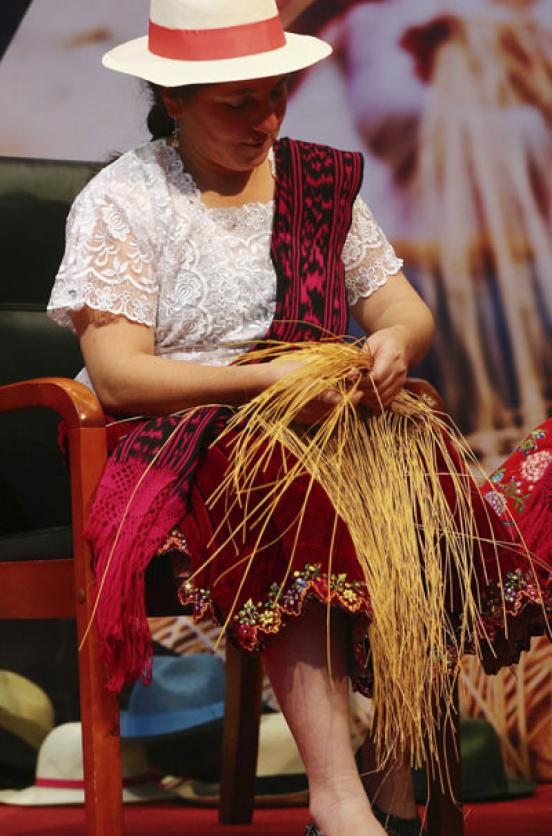 Una mujer ecuatoriana  muestra su habilidad para hacer sombreros de paja toquilla, en China. Foto: EFE